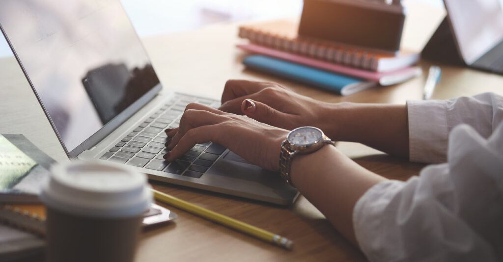 Close up of person typing on a laptop
